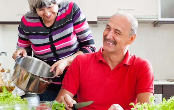 Foto pareja personas mayores preparando una ensalada y sonriendo