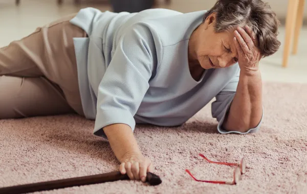 Foto de una mujer mayor caida en el suelo con una aparente fractura de huesos