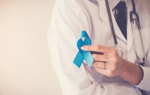Foto de un medico que sostiene un lazo azul referente al cáncer de próstata