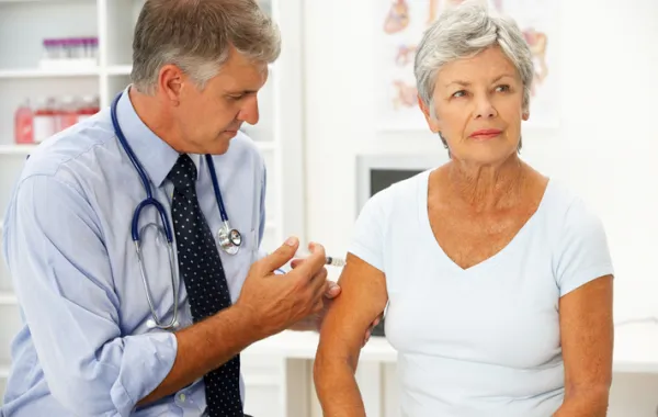 Foto de mujer mayor siendo vacunada por un médico