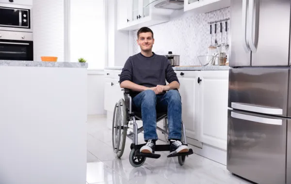 Foto de un señor en silla de ruedas en una cocina