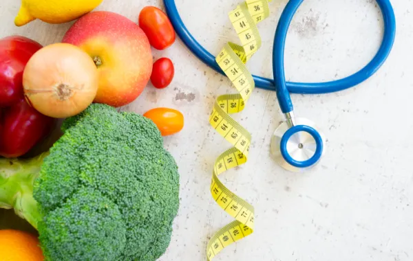 Fotos de varias verduras y frutas al lado de un fonendoscopio 