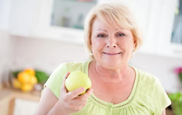 Foto de una señora comiendo una manzana