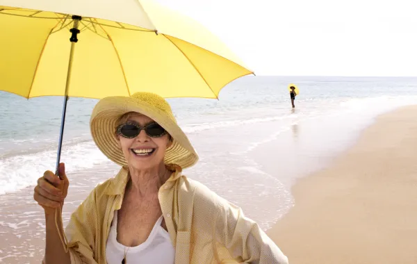 Foto de una mujer con una sombrilla en la playa