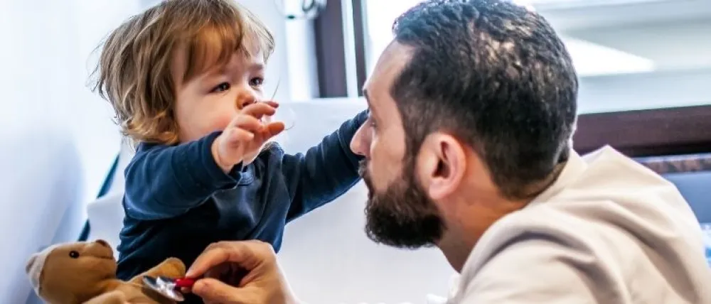 Foto de un niño pequeño que mira a su padre para abrazarle