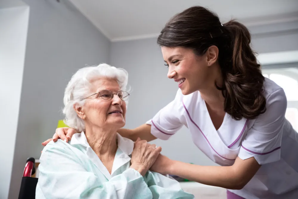 Foto de una mujer mayor atendida por una enfermera joven
