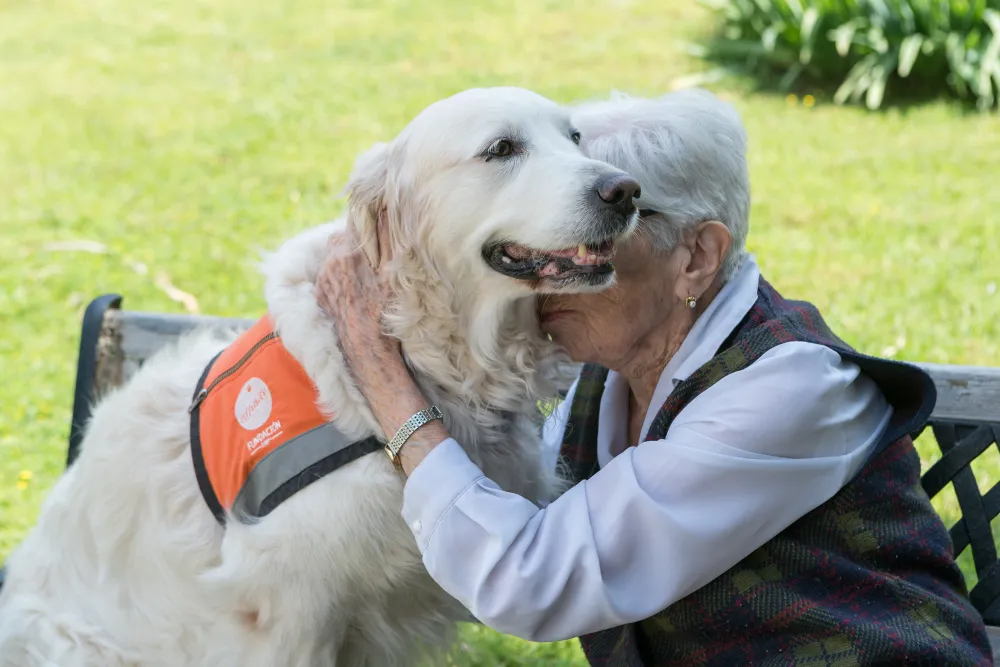 Foto de una mujer mayor abrazando a su perro