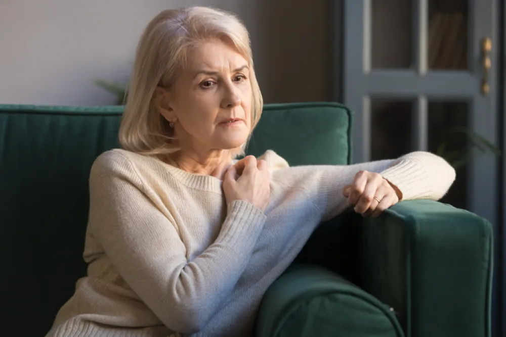 Foto de una mujer mayor sentada con la mirada triste