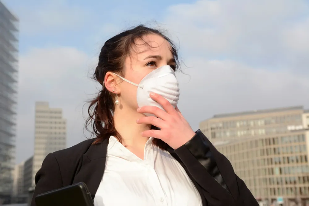 Foto de mujer con una mascarilla para protegerse de la contaminacion