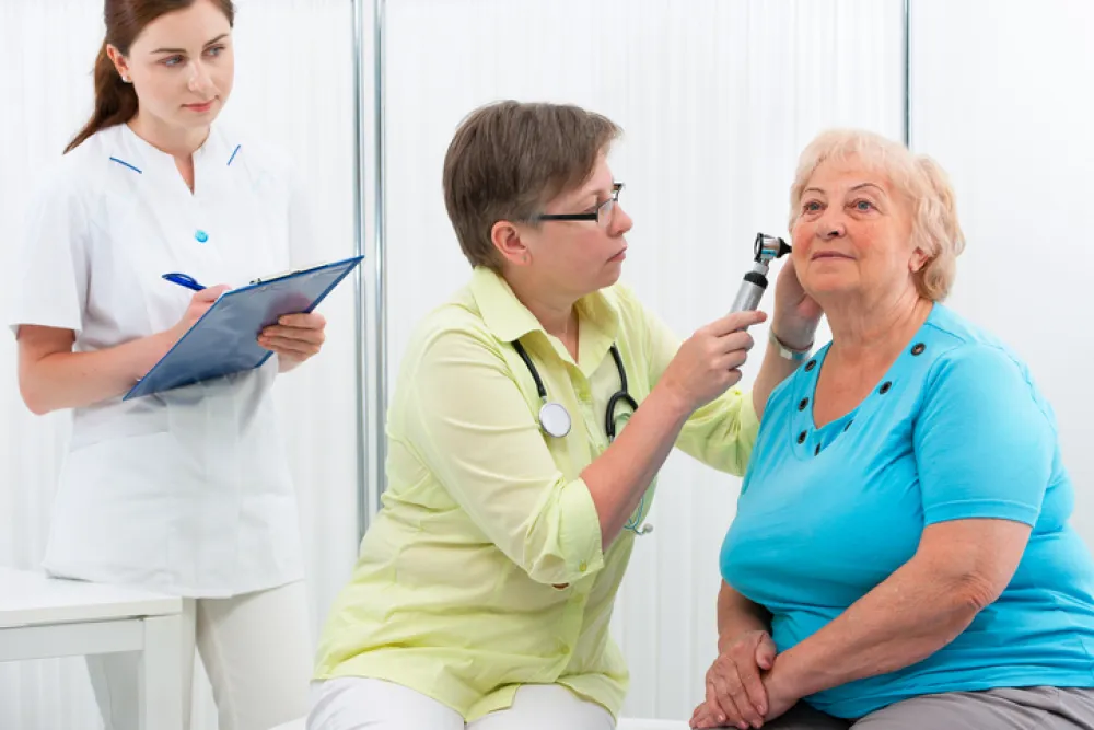 Foto de mujer mayor en una revisión de oidos de un medico