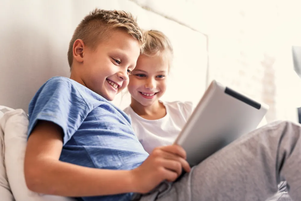 Foto de dos niños menores mirando una tablet
