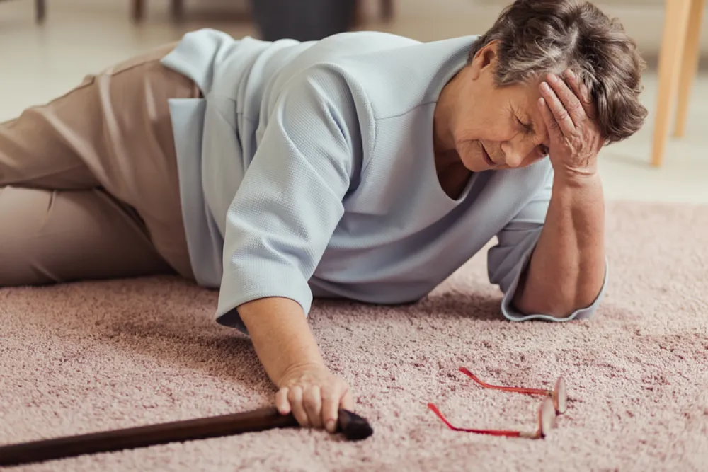 Foto de una mujer mayor caida en el suelo con una aparente fractura de huesos
