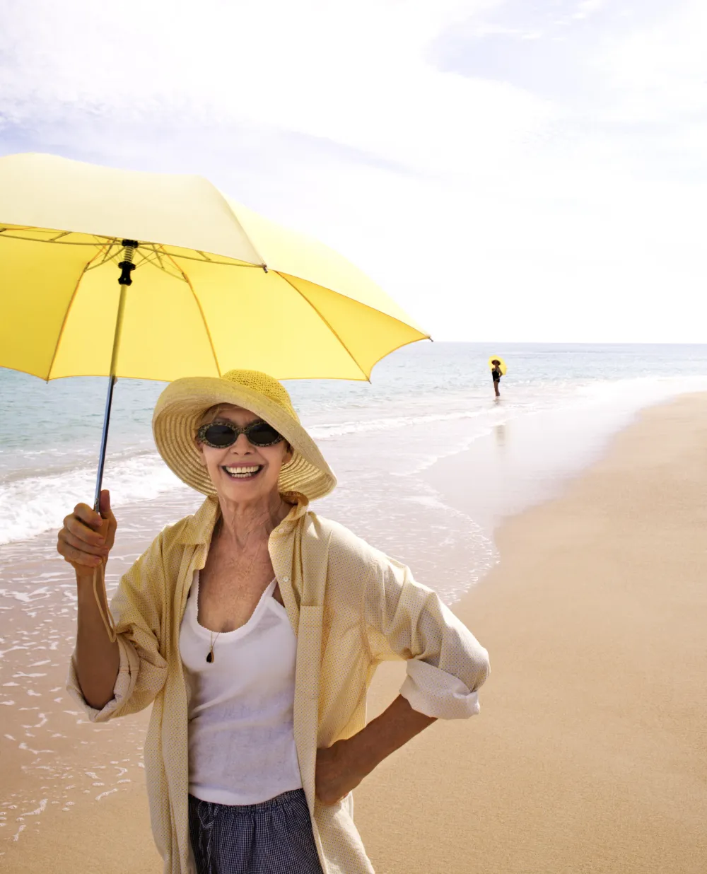 Foto de una mujer con una sombrilla en la playa